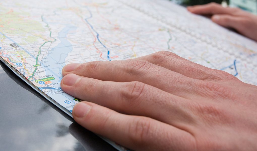 A hand resting on an open road map