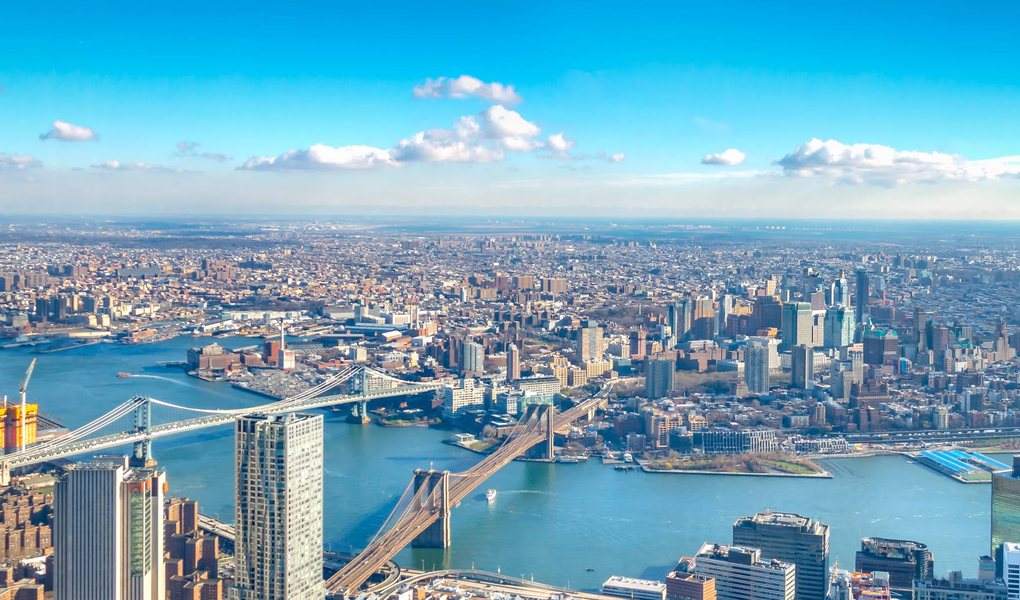 Aerial view across a river toward a dense city skyline