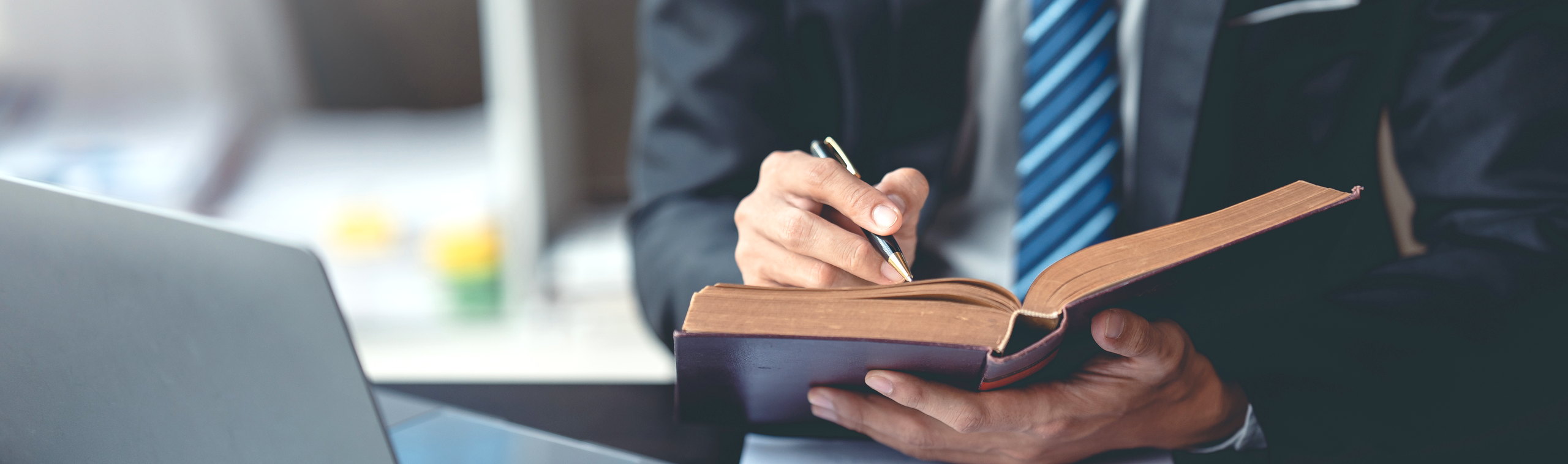 A lawyer making notes beside an open law book