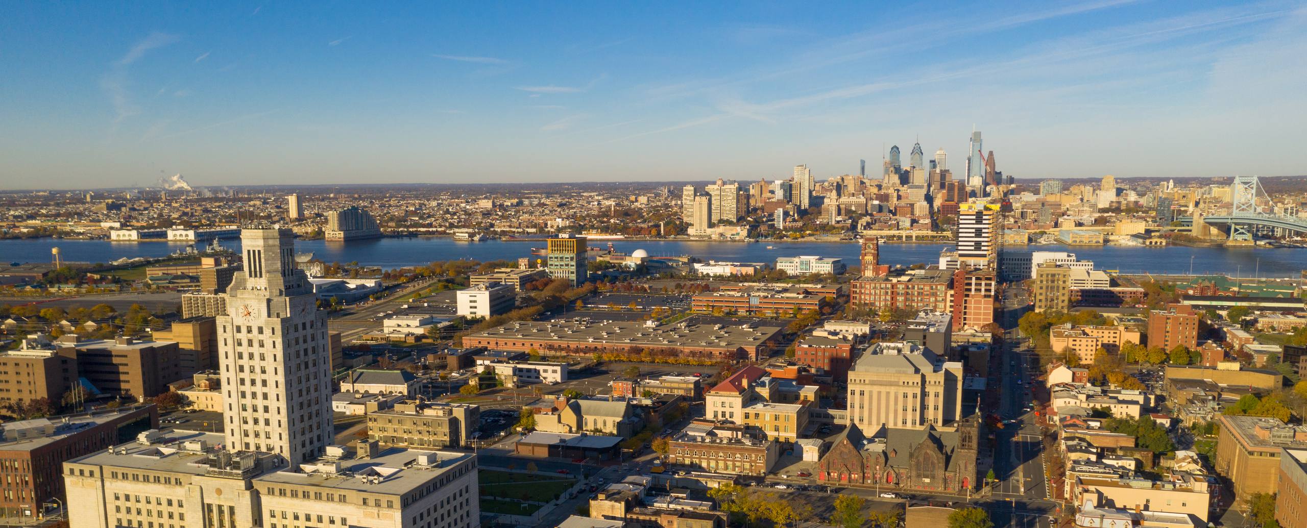 Aerial view over a New Jersey city grid with the downtown skyline beyond