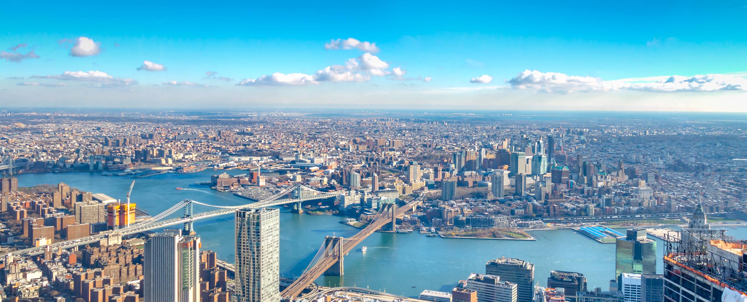 Aerial view across a river toward a dense city skyline