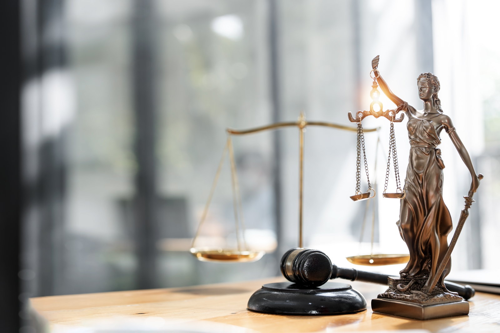 A statue of Lady Justice beside the scales of justice and a gavel in a law office — Newark criminal defense