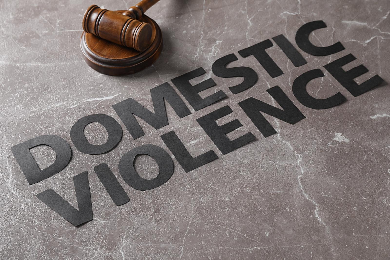A gavel beside the words Domestic Violence set in stone