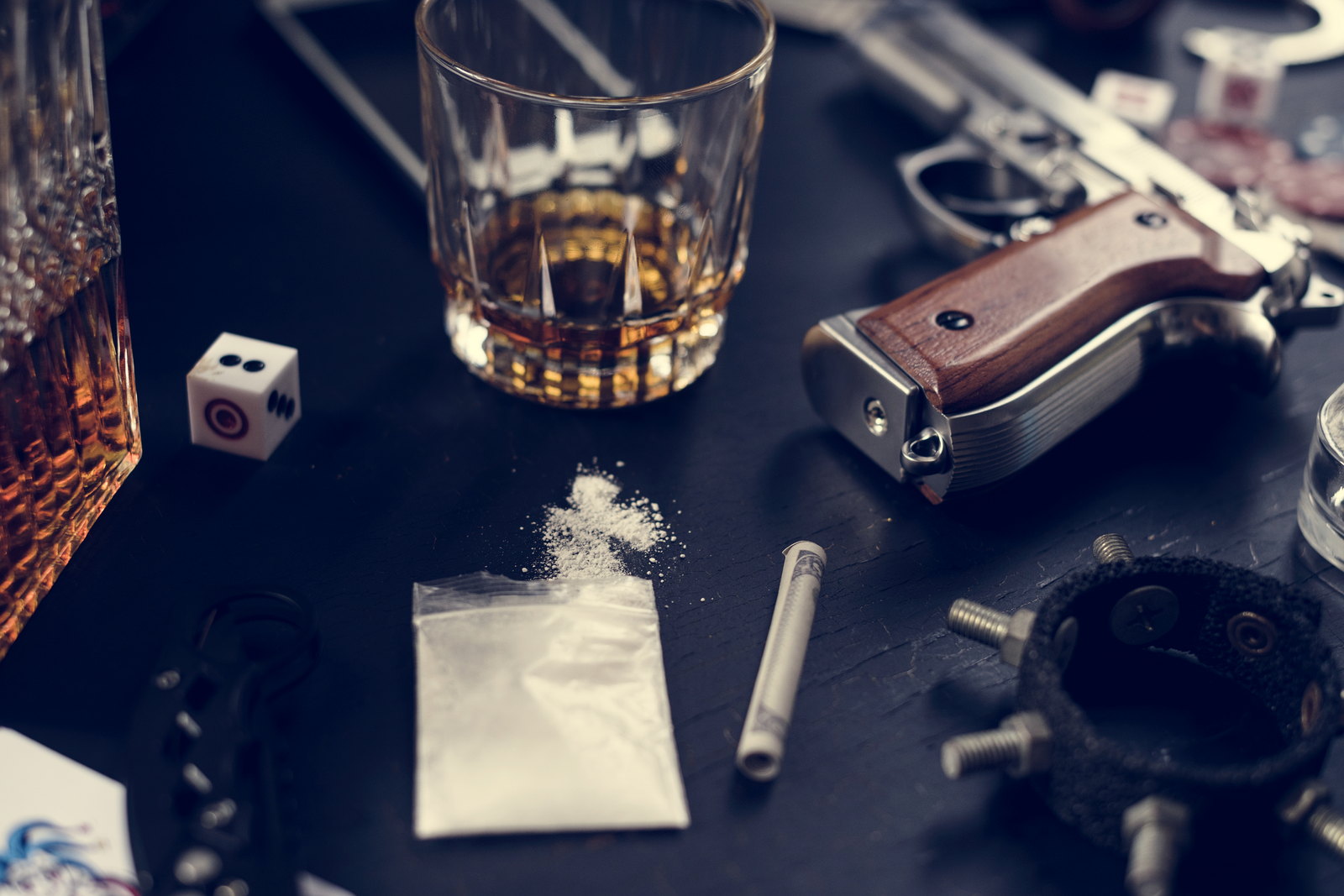 Cash, a firearm and a wrap of powder on a dark surface