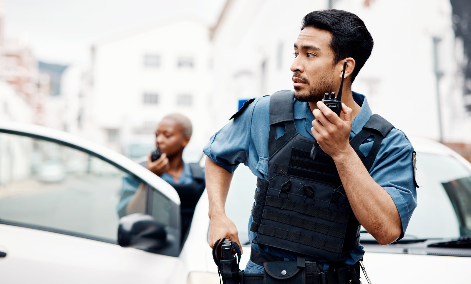 A police officer on the radio beside a patrol car