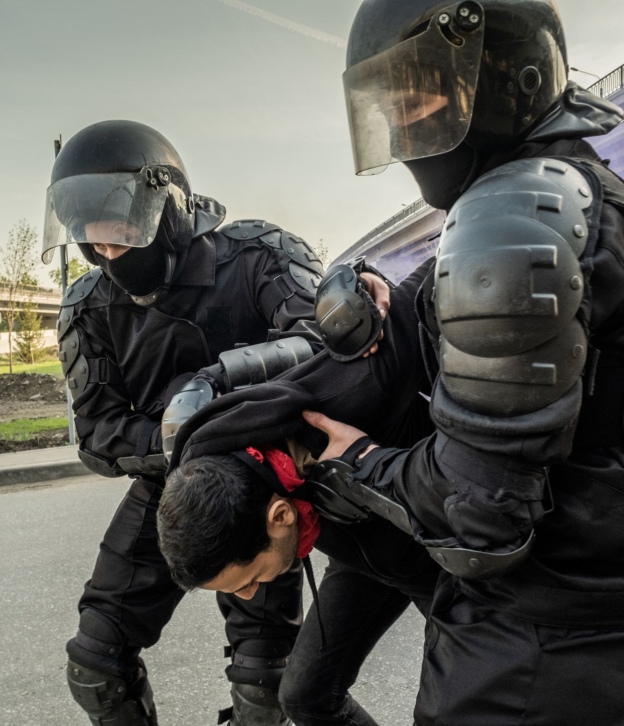 Officers in riot gear restraining a protester