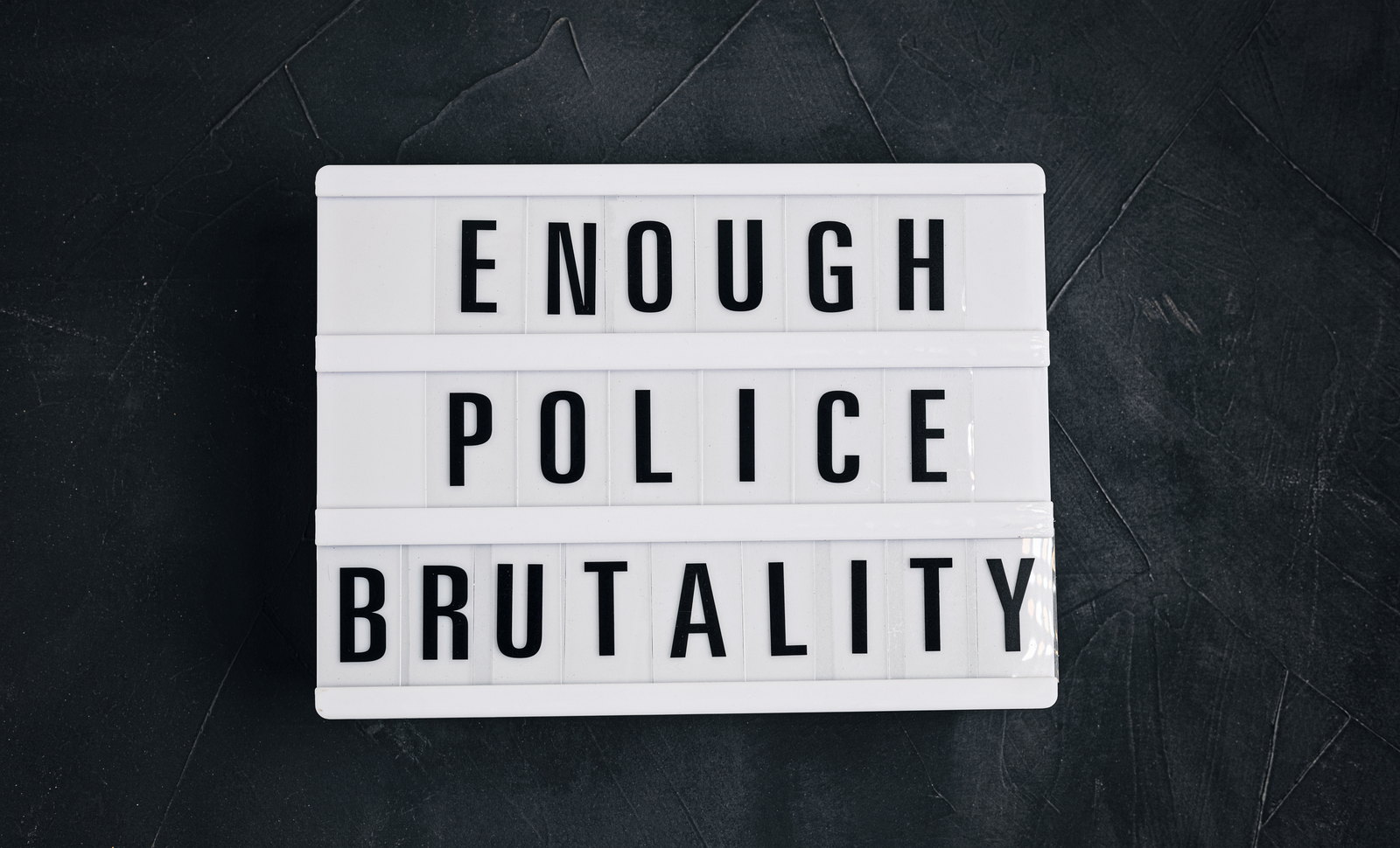 A light box spelling the words Enough Police Brutality