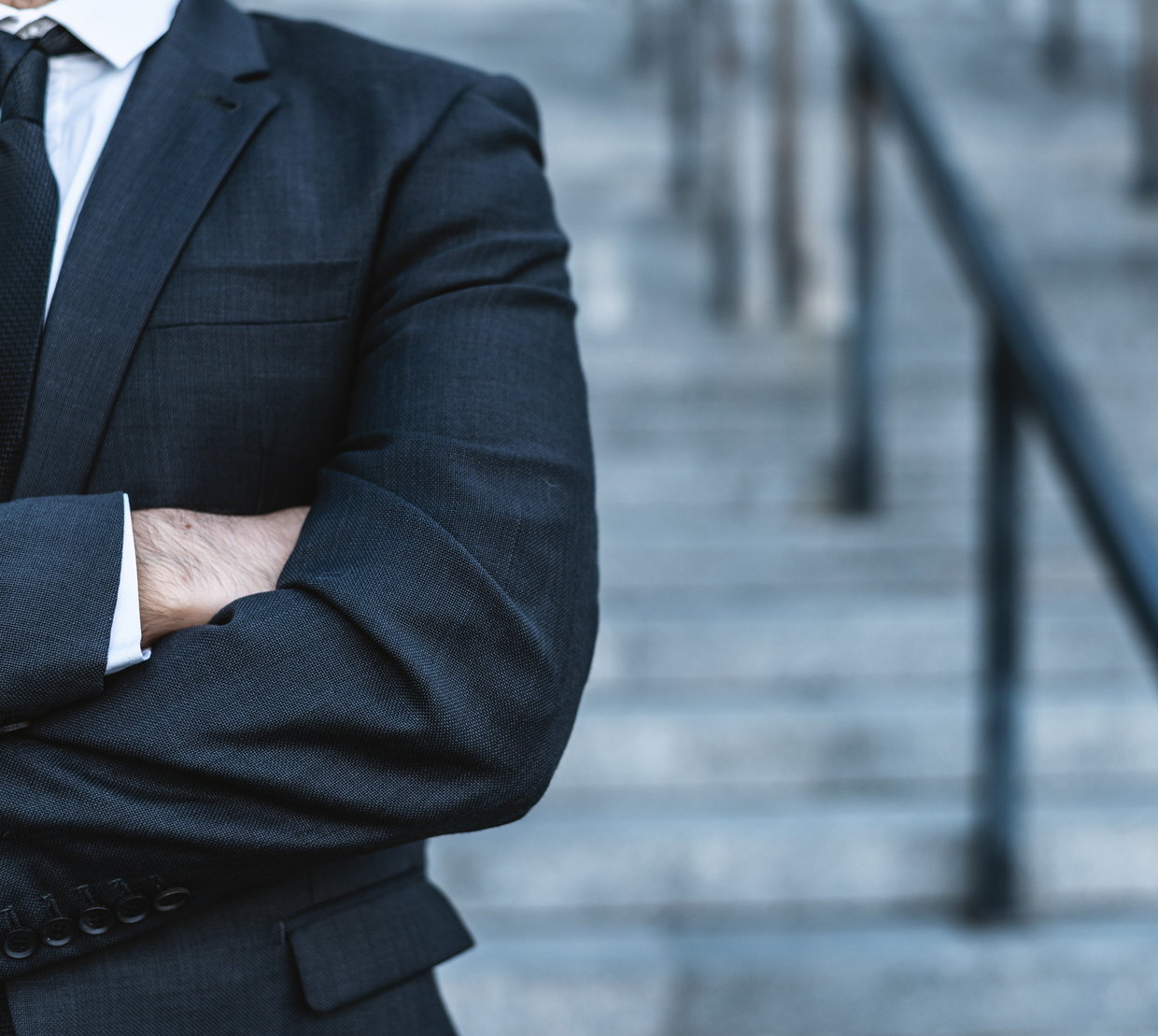 A lawyer in a dark suit standing on courthouse steps