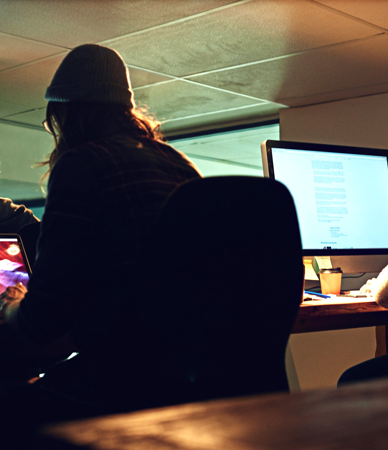 A team working late at screens in an office