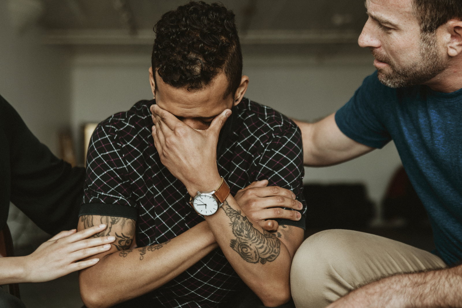 A grieving man supported by friends